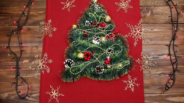 Ένα μικρό χριστουγεννιάτικο δέντρο στολίδια, καρύδια, κορδέλες και διακοσμητικά. Δώρο για ένα χριστουγεννιάτικο δέντρο, ένα vintage ρολόι. 2018, — Αρχείο Βίντεο