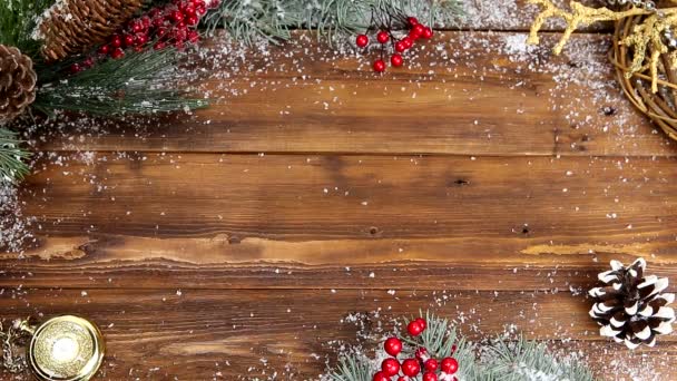 Fondo de madera de Navidad con rama nevada Vista superior. Las manos de una joven pusieron un regalo con un lazo rojo sobre la mesa — Vídeos de Stock