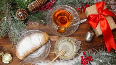 Kış çayı. fincan çay bal ve kruvasan, karda bir Noel ağacı dalı ile. Üstten Görünüm