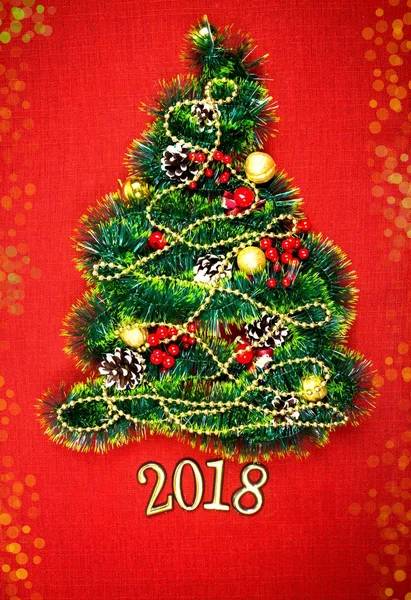 Uma pequena árvore de Natal de ouropel, nozes, fitas e ornamentos. Presente para uma árvore de Natal, um relógio vintage. 2018 , — Fotografia de Stock