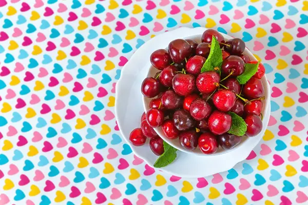 Cerezas en un plato blanco sobre la mesa . — Foto de Stock