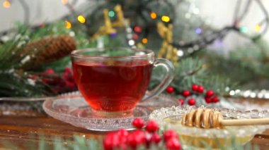 bir fincan çay bal ve Çerezler, kar, Noel ışıkları bir Noel ağacındaki bir dalı ile