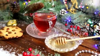 bir fincan çay bal ve Çerezler, kar, Noel ışıkları bir Noel ağacındaki bir dalı ile