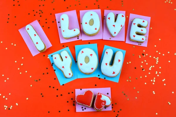 Kue buatan sendiri dalam bentuk hati atau saya mencintai Anda kata-kata pada Hari Kasih Sayang dengan latar belakang merah di atas — Stok Foto