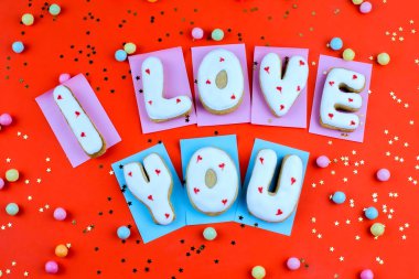 Ev yapımı kurabiye bir kalp şeklinde veya kırmızı arka plan üstten görünüm üzerinde Sevgililer günü sözleri seni seviyorum