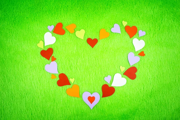 Papier kolorowy serca na zielonym suknem — Zdjęcie stockowe