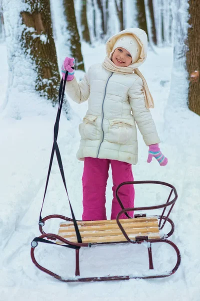 Belle petite fille en hiver dans la neige. toboggan d'hiver. place pour le texte — Photo
