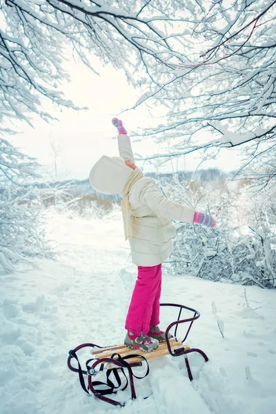 Beautiful little girl in winter in the snow. winter tobogganing. place for text — Stock Photo, Image