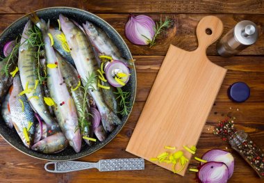 Baharatlar, üstten görünüm ile bir tencerede taze balık levrek. metin için yer