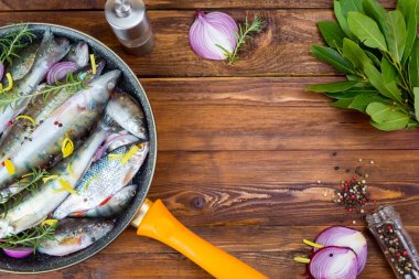 Baharatlar, üstten görünüm ile bir tencerede taze balık levrek. metin için yer