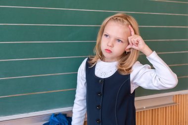 İlk sınıf öğrencisi bir kız okul ders yeşil tahtaya yazma