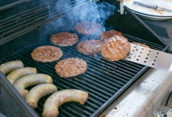 Rond vleespastei en worstjes worden gekookt op de grill. ruimte voor tekst — Stockfoto