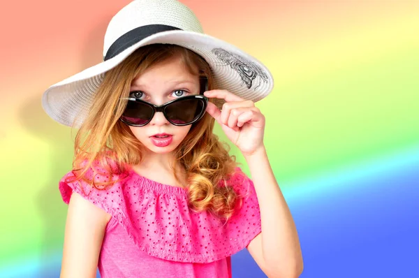 Piękna dziewczynka w różowej sukience, okulary przeciwsłoneczne i kapelusz od słońca na jasnym płaskim tle, emocje dziecka, miejsce na tekst Zdjęcia Stockowe bez tantiem