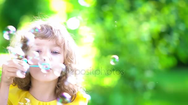 Niño feliz soplando burbujas de jabón — Vídeos de Stock