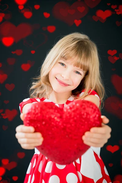 Chica feliz sosteniendo gran corazón rojo — Foto de Stock