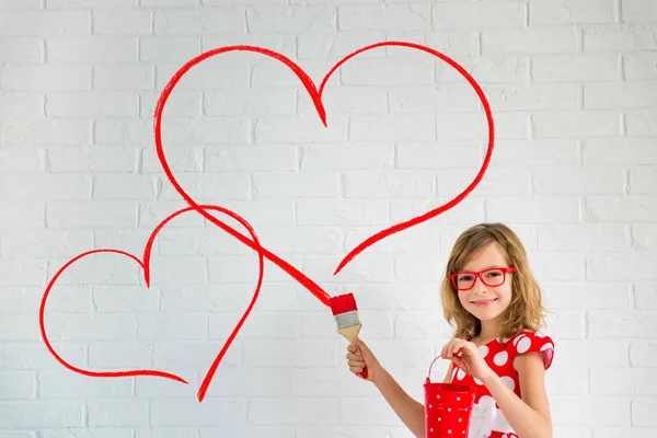 Chica en gafas pintando corazones — Foto de Stock