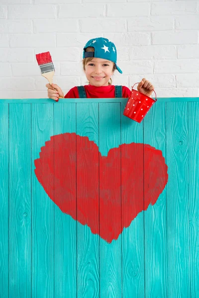 绘画在栅栏上红色的心的女孩 — 图库照片