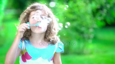 Güzel kız sabun köpüğü üflüyor.