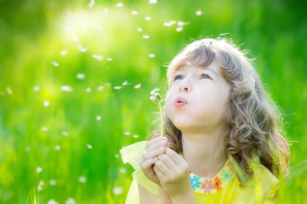 屋外にタンポポの花を吹いて幸せな子 — ストック写真