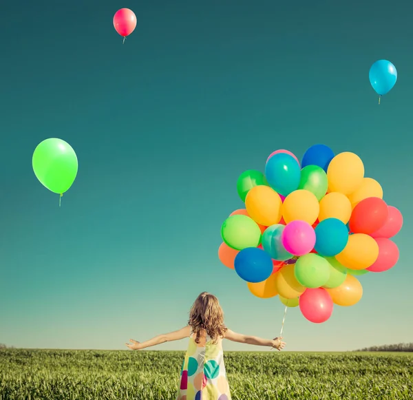 Szczęśliwe dziecko bawi się jasne różnobarwne balony — Zdjęcie stockowe