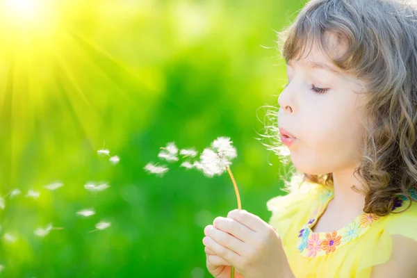 Gelukkig kind waait paardebloem bloem — Stockfoto