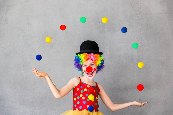 Funny kid clown playing indoor