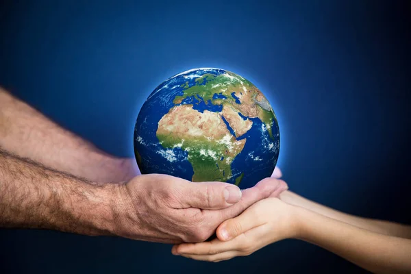 Homme âgé et enfant tenant la planète Terre entre les mains — Photo