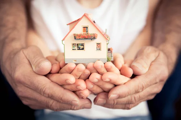 Family holding house in hands — Stock Photo, Image
