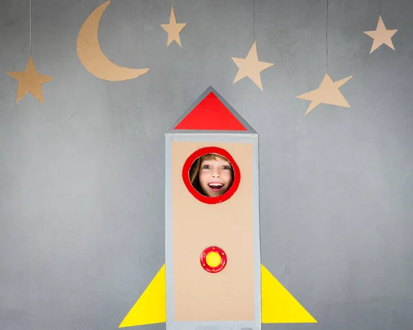 Kid playing with cardboard rocket — Stock Photo, Image