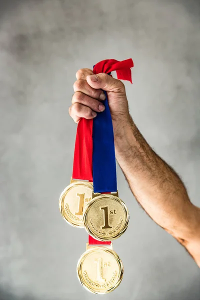 Homem segurando medalhas na mão — Fotografia de Stock