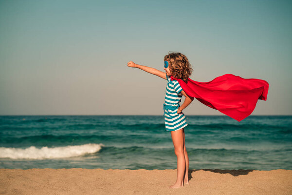 Superhero child on beach