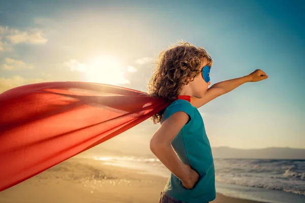 Superhrdina dítě na pláži — Stock fotografie