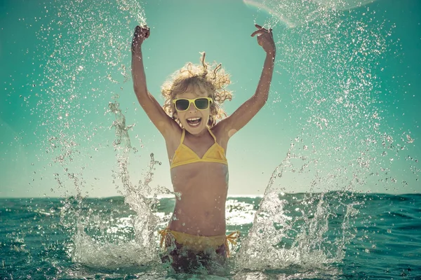 Criança feliz brincando no mar — Fotografia de Stock