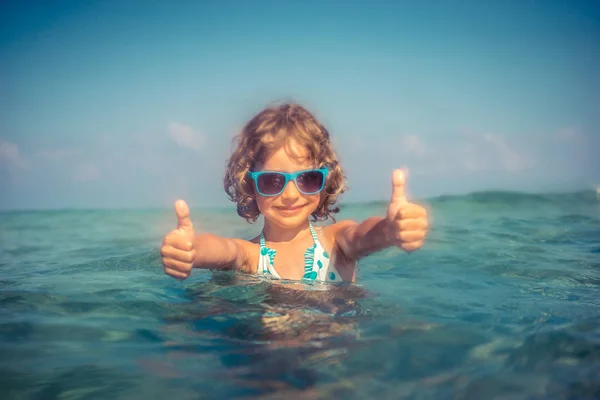 Счастливый ребенок, играющий в море — стоковое фото