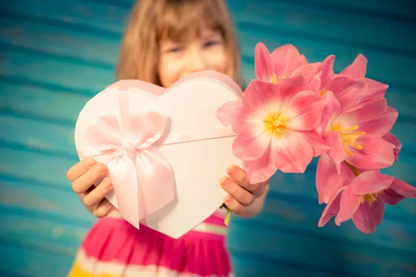 Flicka med bukett blommor och gåva — Stockfoto