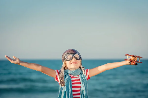 Bambino felice che gioca con aeroplano giocattolo — Foto Stock