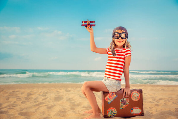 Счастливый ребенок играет с игрушечным самолетом
