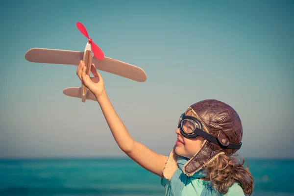 Happy child playing with toy airplane — Stock Photo, Image