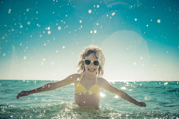Lyckligt barn leker i havet — Stockfoto