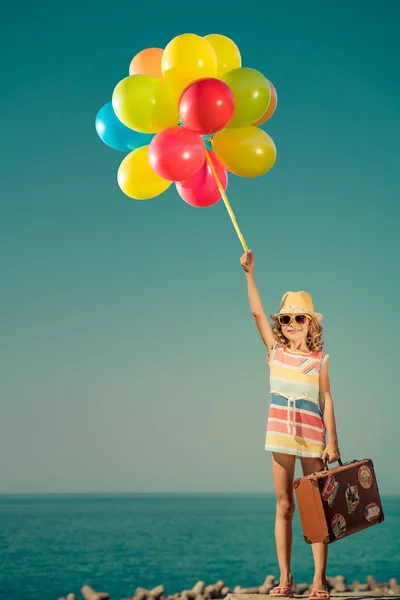 Happy child with colorful balloons on summer vacation — Stock Photo, Image