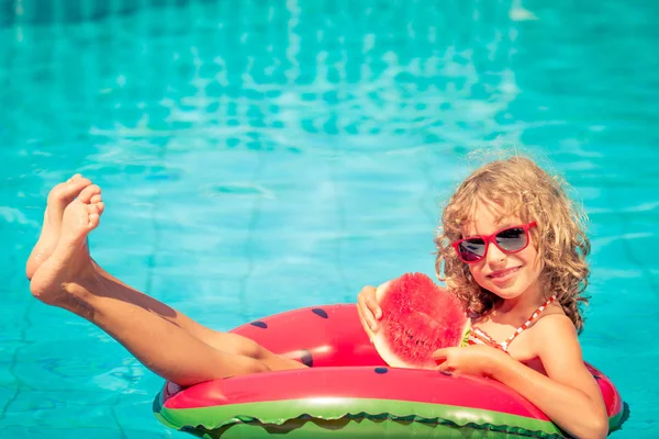 Child with watermelon in swimming pool — Stock Photo, Image