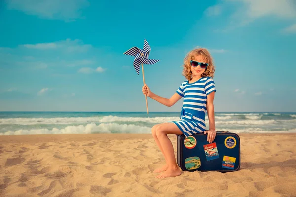 Glückliches Kind spielt draußen gegen Meer und Himmel — Stockfoto