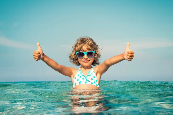 Criança feliz brincando no mar — Fotografia de Stock