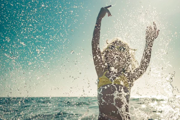 Criança feliz brincando no mar — Fotografia de Stock