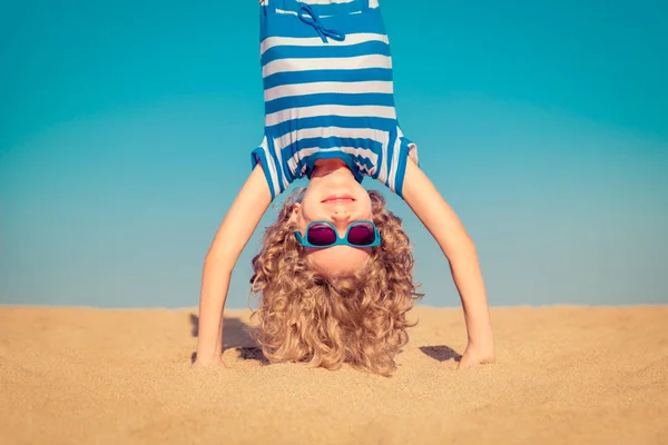 Lustiges Kind steht kopfüber am Sandstrand — Stockfoto