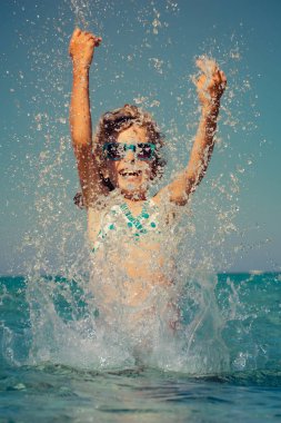 Denizde oynayan mutlu çocuk