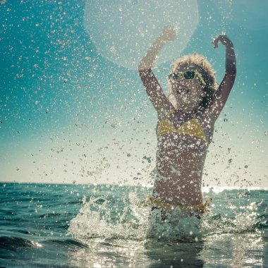 Denizde oynayan mutlu çocuk