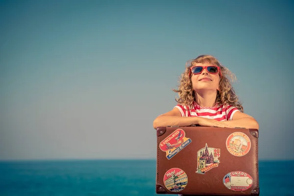Ребенок с винтажным чемоданом на летних каникулах — стоковое фото