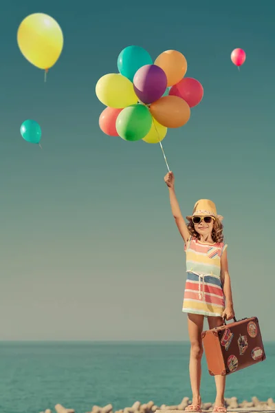 Ευτυχισμένο παιδί με πολύχρωμα μπαλόνια στις καλοκαιρινές διακοπές — Φωτογραφία Αρχείου