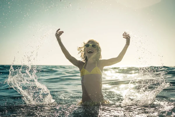 Criança feliz brincando no mar — Fotografia de Stock